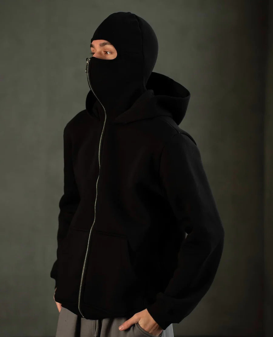 Model wearing oversized Ninja Hoodie with face mask fully zipped for smog protection in Lahore.